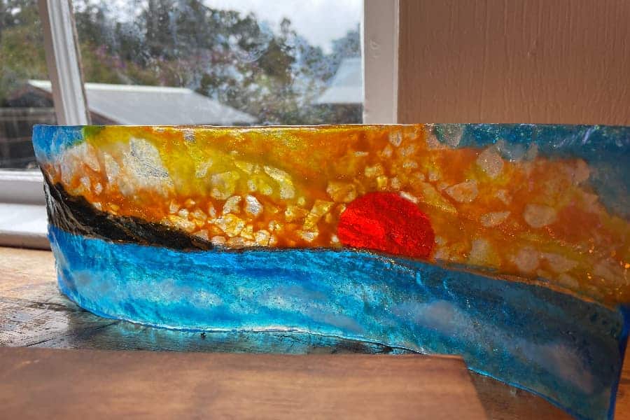 Glass sculpture of a sunset over the water